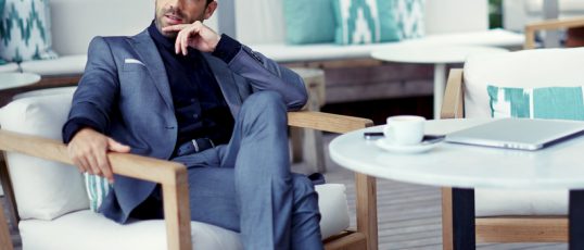Portrait of successful businessman in a luxury expensive suit resting at cafe after hard work day and look pensive,rich entrepreneur waiting for a meeting with colleague at open air restaurant terrace